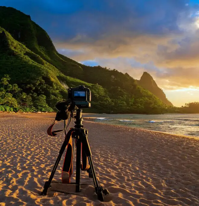 Photography setup on a beach with lush mountains and ocean in Kauai