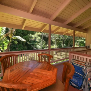 River Estate — Kauaʻi North Shore Vacation Rental | Gallery Deck of The Guest House at River Estate with table, beach gear, and river view