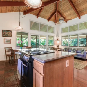 Relax in the luxurious living room of The Guest House at River Estate, Kauai, with stunning river views and elegant furnishings. Living room of The Guest House at River Estate with river view and luxurious furnishings