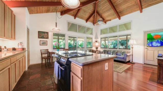 Relax in the luxurious living room of The Guest House at River Estate, Kauai, with stunning river views and elegant furnishings. Relax in Elegance with Stunning River Views