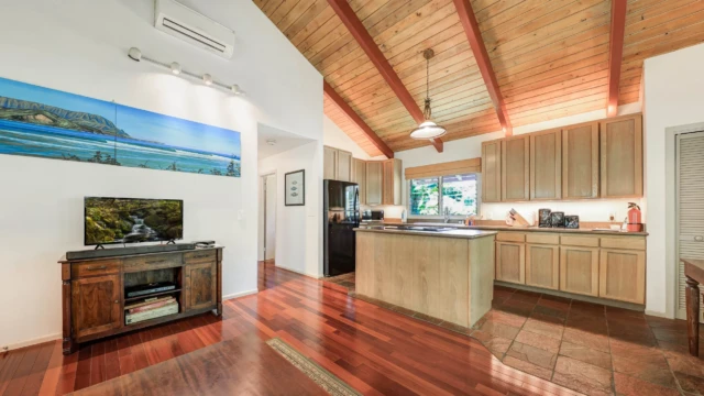 Relax in the elegant living room and kitchen of The Guest House at River Estate, Kauai, with top-quality furnishings and modern amenities. Elegant Living Room and Kitchen with Modern Comforts