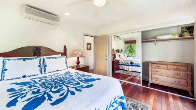 Relax in the cozy third bedroom at The River House, River Estate, featuring a comfortable chair and a view of the hallway door. Cozy Third Bedroom with Hallway Door View