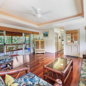 River Estate — Kauaʻi North Shore Vacation Rental | Gallery Living room of The River House at River Estate with view of patio dining area and elegant hutch