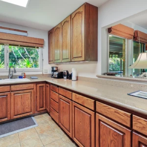 Enjoy the convenience of the kitchen with a pass-through window at The River House, River Estate, perfect for serving meals and entertaining. Kitchen with pass-through window at The River House, Kauai Vacation Rental