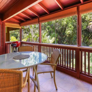 Enjoy the sustainable and relaxing lanai at The River House, River Estate, featuring a BBQ, Tesla battery, and stunning river view. Lanai at The River House, River Estate with BBQ, Tesla battery, and river view