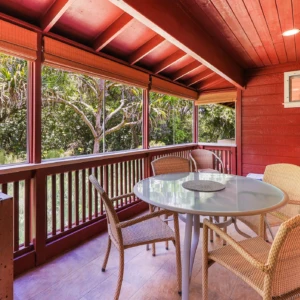 Enjoy the serene river view from the lanai at The River House, River Estate, surrounded by lush greenery. Lanai at The River House, River Estate with river view