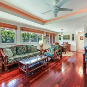 A bright and airy living room with tropical decor, featuring comfortable seating and a dining area. Perfect for a Kauai vacation rental. Bright and airy living room with tropical decor and dining area.